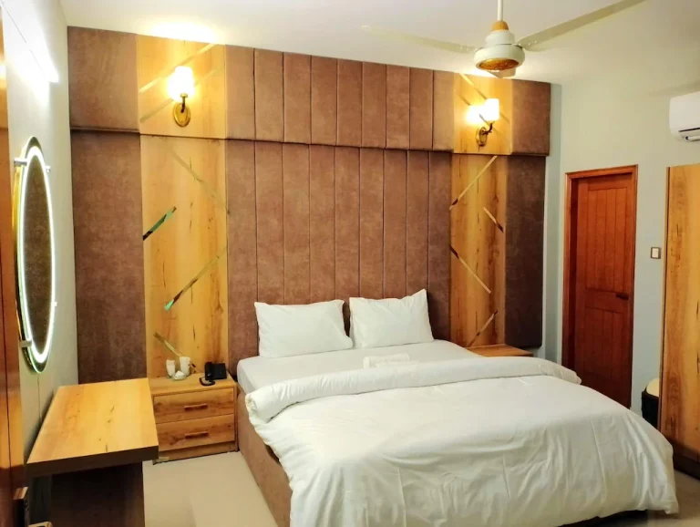 Deluxe Double Room with king bed, seating area and city-view balcony in DHA Karachi